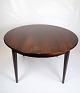 A round 
rosewood dining 
table, model 55 
by Omann Junior 
with three 
additional 
plates, one of 
...