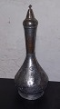 Indian metal 
bottle with 
stopper. 
Decorated with 
foliage around 
the container. 
Corresponding 
...