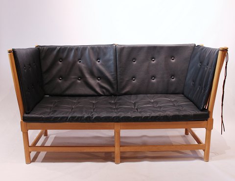 Spokeback sofa in beech and with originally upholstered cushions of classic 
black leather, designed by Børge Mogensen, 1985.
5000m2 showroom.