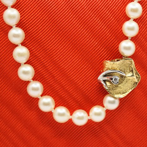 Ole Lynggaard; Clasp of 14k gold with a diamond