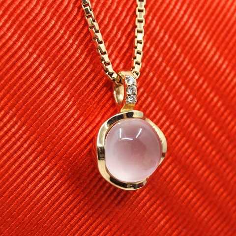 A pendant in 14k gold set with a rose quartz and diamonds A pendant in 14k gold set with a rose quartz and diamonds