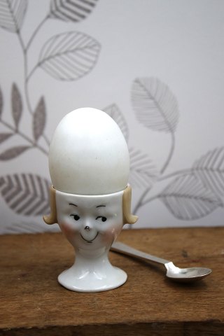Old egg cup from the 1930s in porcelain with a painted funny face.