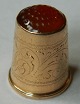 Gold timble 
with red stone 
on the top. 
Beautifully 
decorated 
around the 
timble. Gold 
mark 585 ...