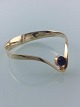 Danish bangle 
of 14k gold 
with amethyst 
by Bent 
Gabrielsen. 
Diam. 6,5 cm