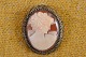 Cameo, adorable 
lady head 
carved from 
conch, mounted 
in silver frame 
with . The 
jewelery is 
both ...