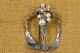 Brooch silver 
artfully 
crafted, 
hammered, cut 
and decorated 
with 9 pearls 
of different 
sizes. ...