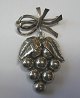 Brooch in 
silver as a 
bunch of grapes 
with a bow. 
Stamped .: 830 
p. Denmark, 
John L for ...