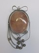 Polished amber brooch, 20th century. With silver filigran. Stamped. Height: 5 cm.