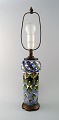 Aluminia 
faience table 
lamp, hand 
painted with 
floral motifs.
Measures: 
Overall height 
56 ...