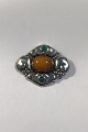 Evald Nielsen 
Silver Brooch 
with 
Ambercenter and 
green stones 
Clasp partly 
renewed 
Measures 5,6 
...