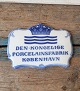 Royal 
Copenhagen 
retailer plaque 
with the text 
"Den Kongelige 
Forcelænsfabrik 
København" 
No. ...