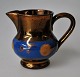 English luster 
jug, 19th 
century. 
Decoration with 
blue ribbon and 
circles. H: 6.2 
cm.