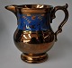 English luster 
jug, 19th 
century. With 
blue ribbon 
decoration and 
leaf patterns. 
H: 11 cm.