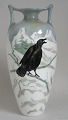 Vase, Holland, 
ca.1900 in 
faince. With 
motif of crow 
sitting on a 
branch between 
the snowy ...