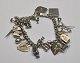 Iron bracelet, USA, 20th century with 20 charms. L: 16 cm. Several charms in sterling silver.