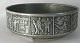 Tin table bowl, 
with 
Greenlandic 
motifs from 
catch and 
sledding. Ca. 
1960. H: 6.5 
cm. Dia.: 19 
...