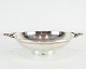 Bowl on foot 
with handles 
and decorated 
with carvings 
of hallmarked 
silver.
4.5 x 16 cm.