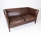 The two-seater 
sofa in dark 
brown leather, 
Danishly 
designed and 
manufactured by 
Stouby ...