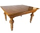 Large dining 
table of light 
wood with 
carvings and 
three extension 
plates from the 
1920s. The ...