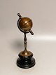 Patinated brass 
money box in 
the form of a 
globe on a 
wooden plinth 
Height 29.5 cm.