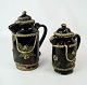Set of two 
German black 
clay jugs 
decorated with 
gold and 
flowers from 
1860. 
24/20 x 10x9 
cm.
