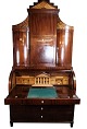 Large Empire bureau of polished mahogany  with inlaid wood and decorated with carvings, from the ...