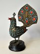 Peacock with 
coral and 
turquoise, 20th 
century South 
America. Of 
gilded metal. 
On round wooden 
...