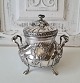 Beautiful sugar 
bowl in rococo 
inspired design 
with rose as 
lid. 
Inside gilded. 

Stamp: ...
