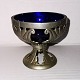 Mogens Ballin´s successor: Openwork tin bowl with art nouveau work decorations. In it blue glass ...
