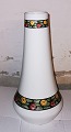 High conical 
Art Deco vase 
in porcelain. 
Decorated with 
floral ribbons 
at the top and 
bottom of ...
