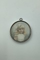 Watercolor 
miniature 
portrait of 
blonde girl 
with bow in 
hair from c. 
1900. Inserted 
in metal ...