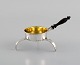 European 
silversmith. 
Antique silver 
tea strainer on 
tripod with 
shaft in turned 
ebony. Gilded 
...