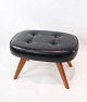 Stool of Danish design with black leather and teak legs from around the 1960s. The stool has 4 ...
