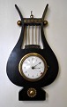 French lyre shaped wall clock, 19th century Empire. Black polished wood with brass decorations. ...