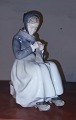 Royal 
Copenhagen 
figure in 
porcelain of 
young woman in 
regional 
costume 
knitting. Model 
number ...