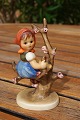 Goebel figurine or Hummel figurine from the period 1960-1972.Girl sitting on a branch in the ...