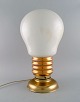 Large table lamp in brass and opal glass shaped like a light bulb. 1960s.Measures: 49 x 27 ...