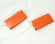 Set of two wall lamps in an orange color with light cord of Danish design from around the ...