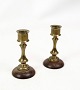 A pair of brass candlesticks in miniature size with a wooden base from the 1930s. A beautiful ...