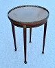 Small French round table, 20th century. Veneered - with marquetry. Tapered legs with bronze ...