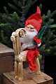 Old Santa Claus 
with cotton 
beard, Santa 
hat, small 
Christmas tree 
sitting on a 
Christmas buck 
...