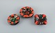 Vallauris, 
France, three 
ceramic bowls 
in brightly 
colored glazes 
in red and 
green on a dark 
...