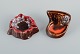 Vallauris, 
France, two 
ceramic bowls 
in brightly 
colored glazes 
in red and 
orange on a 
dark ...