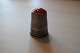 Old thimbles 
made of silver
With a red 
fluss
No stamps
Decoration in 
the silver like 
a runner ...