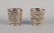 Chinese silversmith. Two small goblets richly decorated in relief with flowers and ...