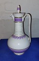 Royal 
Copenhagen jug 
In porcelain 
with matching 
lid. Purple and 
white. Cut on 
the lid and on 
the ...
