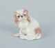 Dahl-Jensen for 
Bing & 
Grøndahl, small 
porcelain 
figurine of a 
sitting 
Pekingese dog.
Model ...