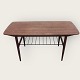 Coffee table in teak veneer with metal newspaper shelf and bast mounting at the ends. Appears in ...