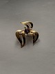 Fine gold brooch with nice curved pattern, in 14 carat gold and blue stone in the middle. The ...