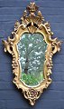 Gilded rococo mirror, 20th century. Decorations with rosettes, foliage and flowers. Height: 81 ...